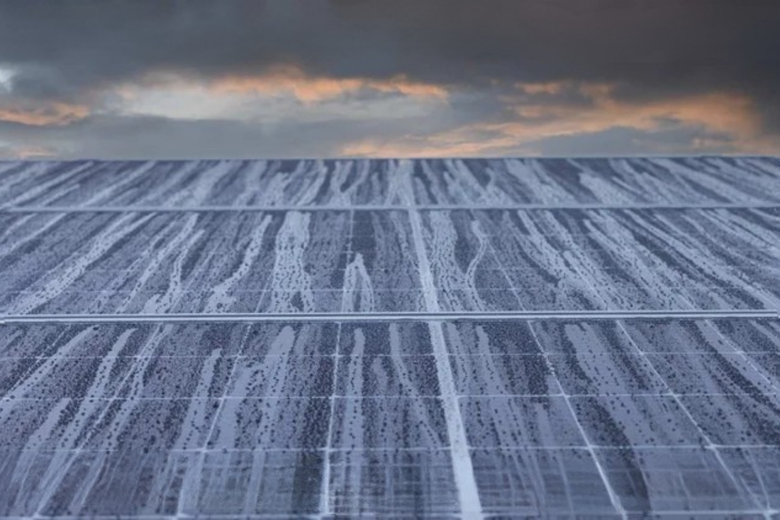 Rain drops trickle down solar panels.