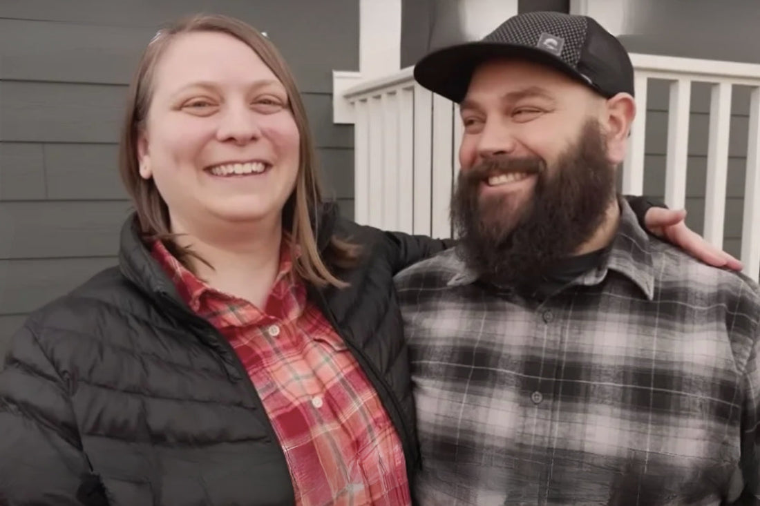 Ryan and Megan stand together outside their home smiling at the camera.