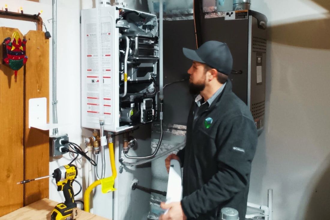 A worker from GreenSavers works on the installation of a water heater.