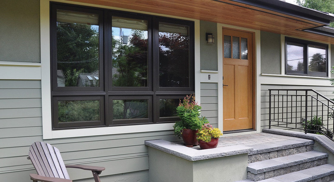 The front of a house showing 4 windows and the front door.