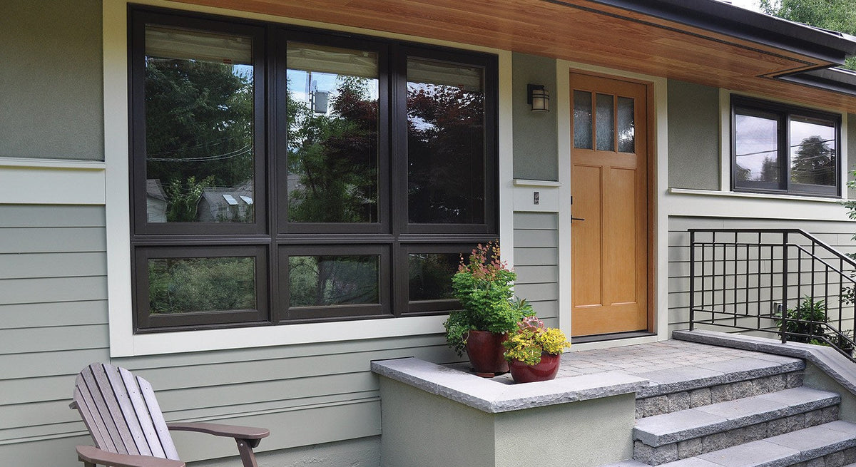 The front of a house showing 4 windows and the front door.